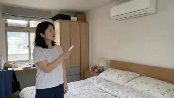 台灣住戶察覺冷氣霉味並檢查室內機的情境示意
